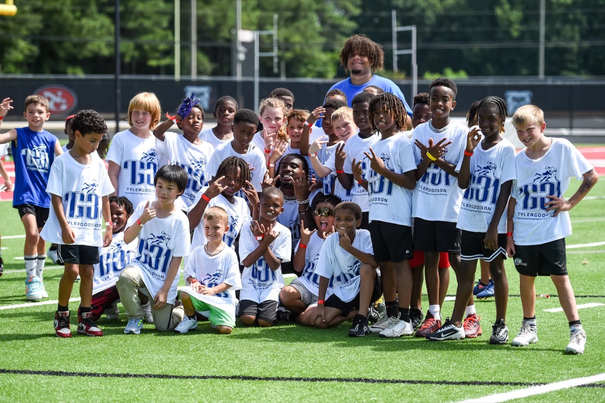 Tyler Goodson with camp group on the field